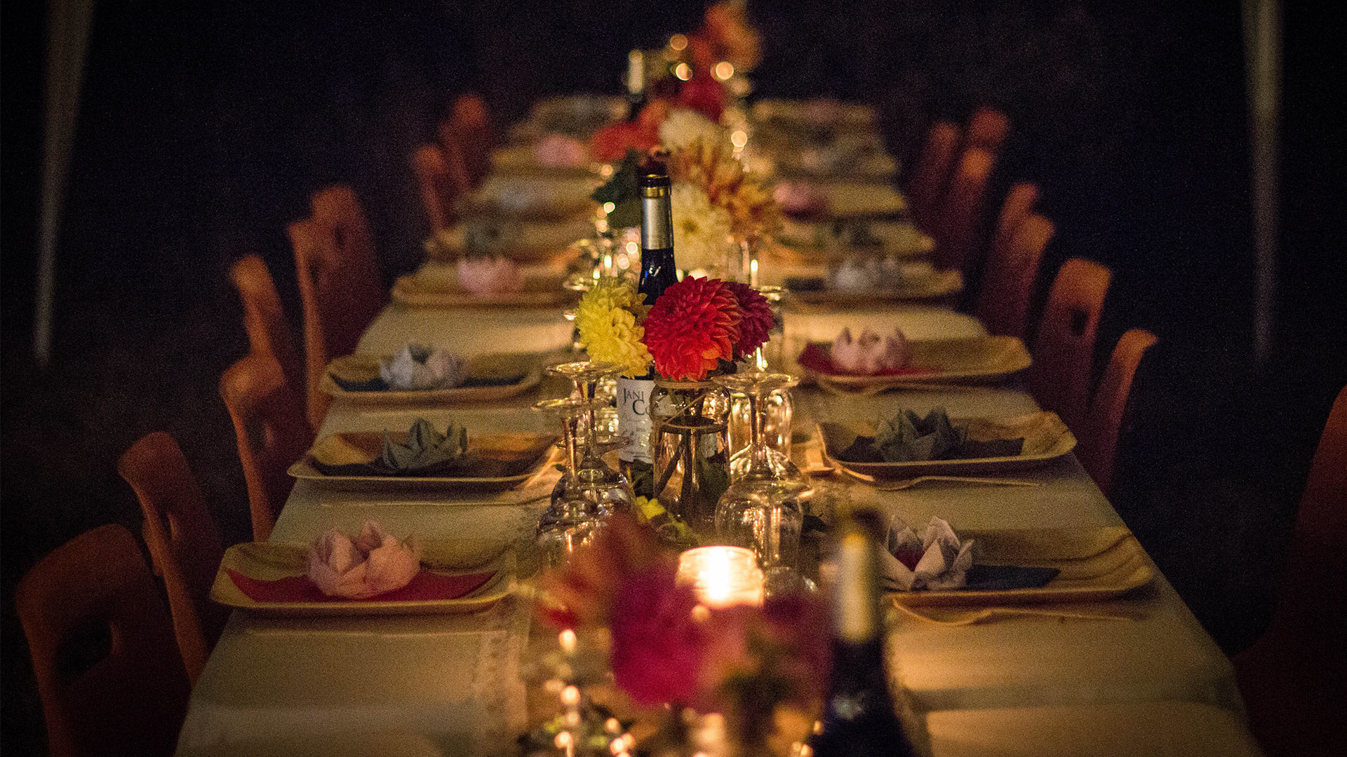 a banquet table set with flowers and warm candles