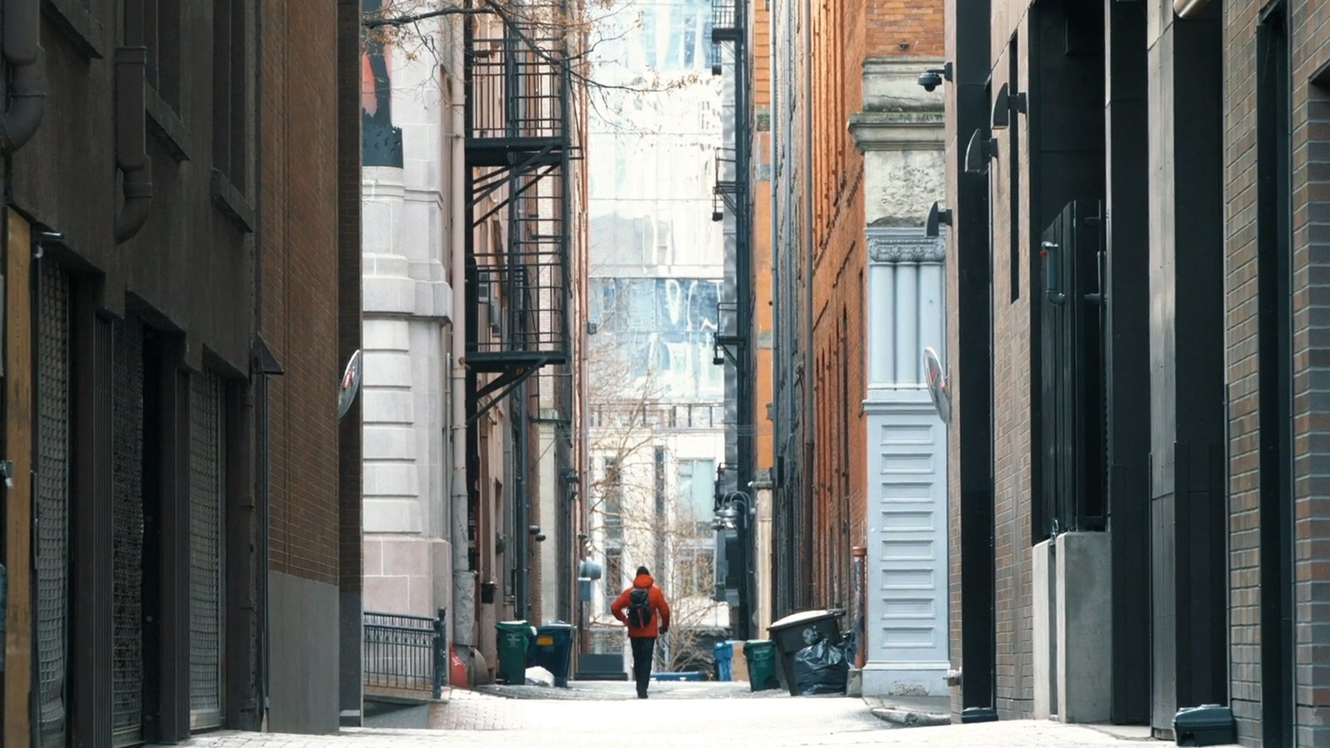 a person walking down a city alleyway